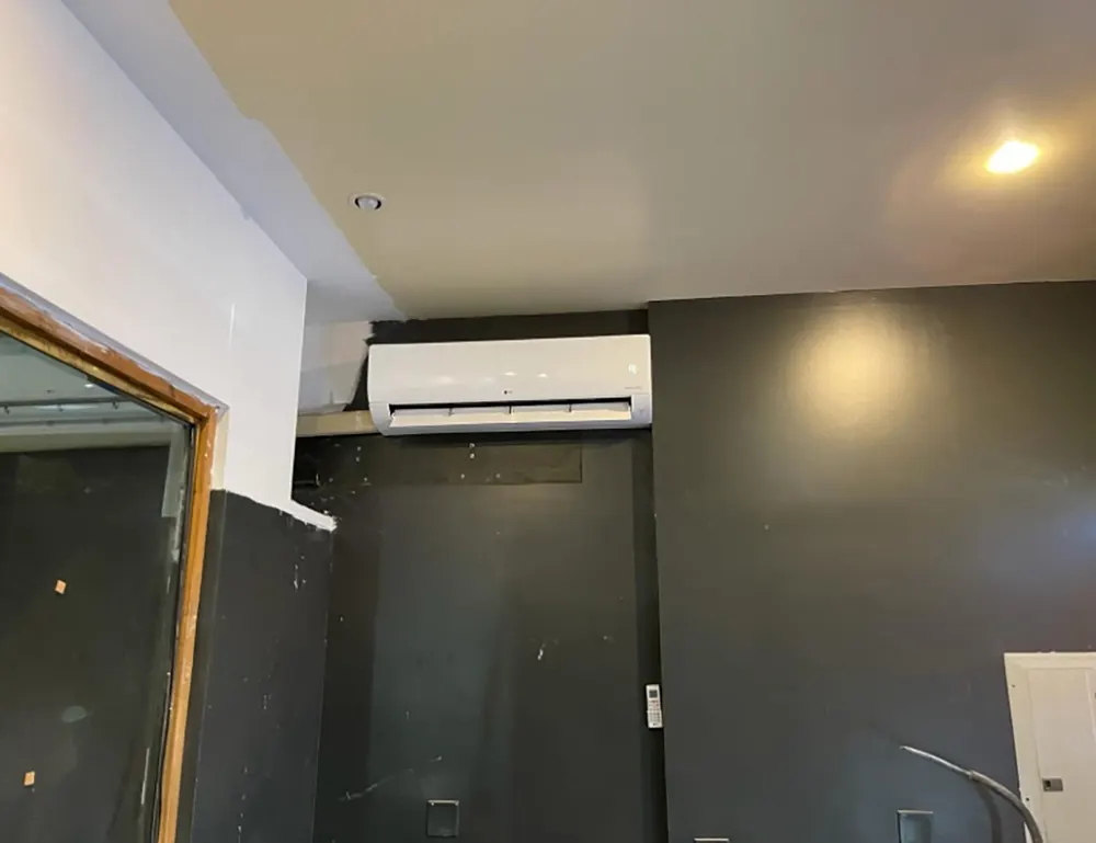 Ductless mini-split unit on an exposed brick wall in a renovated Brooklyn brownstone